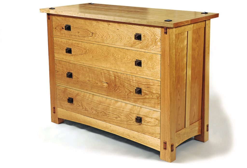 Wooden chest of drawers with black handles.