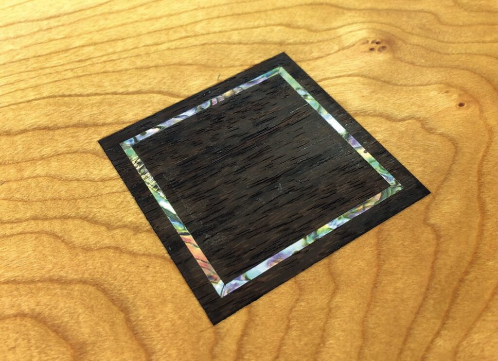 Wooden inlay on a light wood surface.