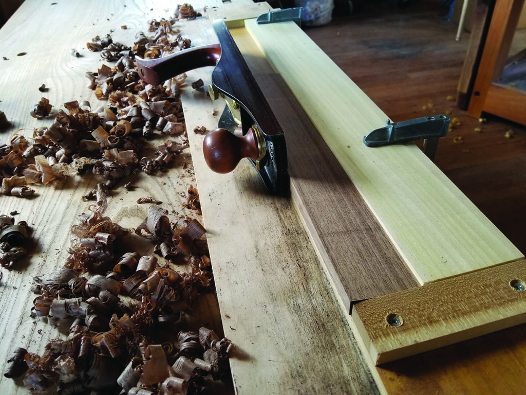 Wood shavings and hand plane on workbench.