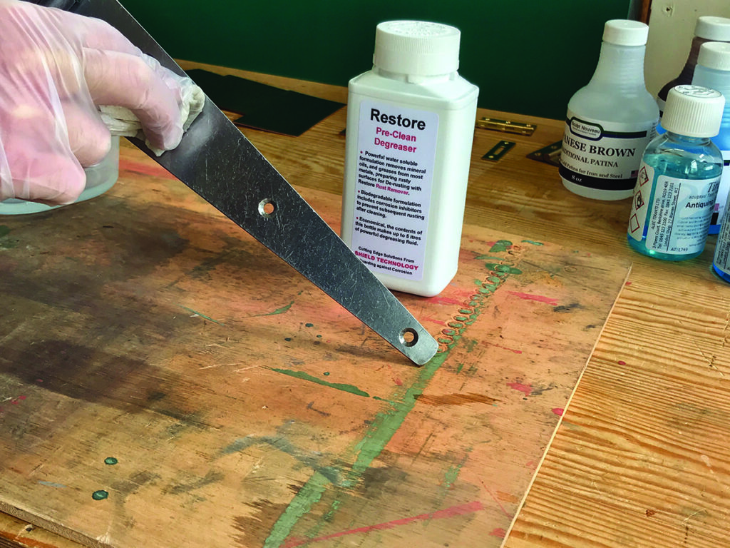 Using a metal tool to clean a wooden surface.