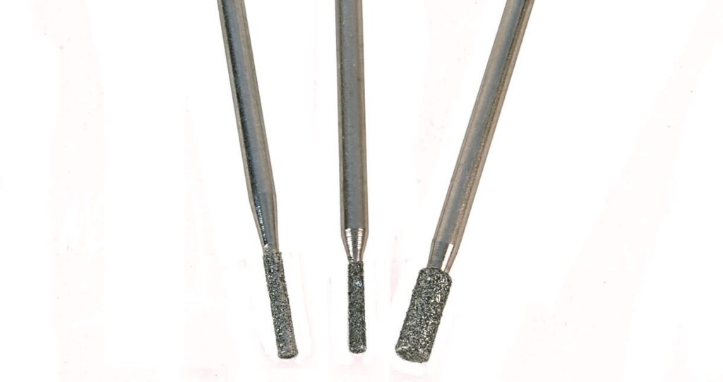 Three diamond-coated dental burs on white background.