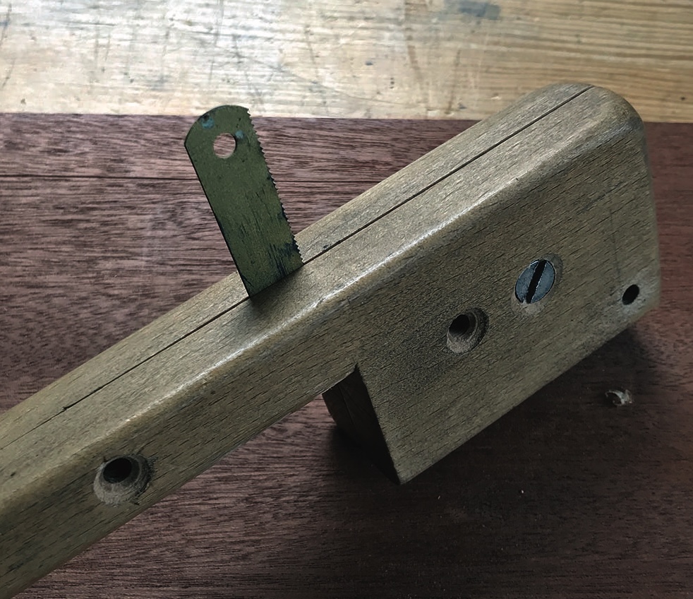 Wooden marking gauge on table surface.