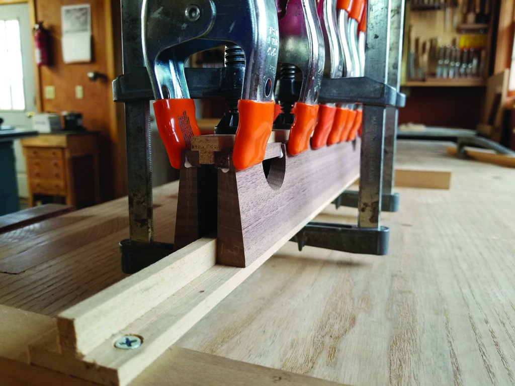 Woodworking clamps securing a wooden plank.