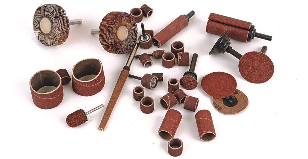 Assorted sanding attachments and discs on white background.