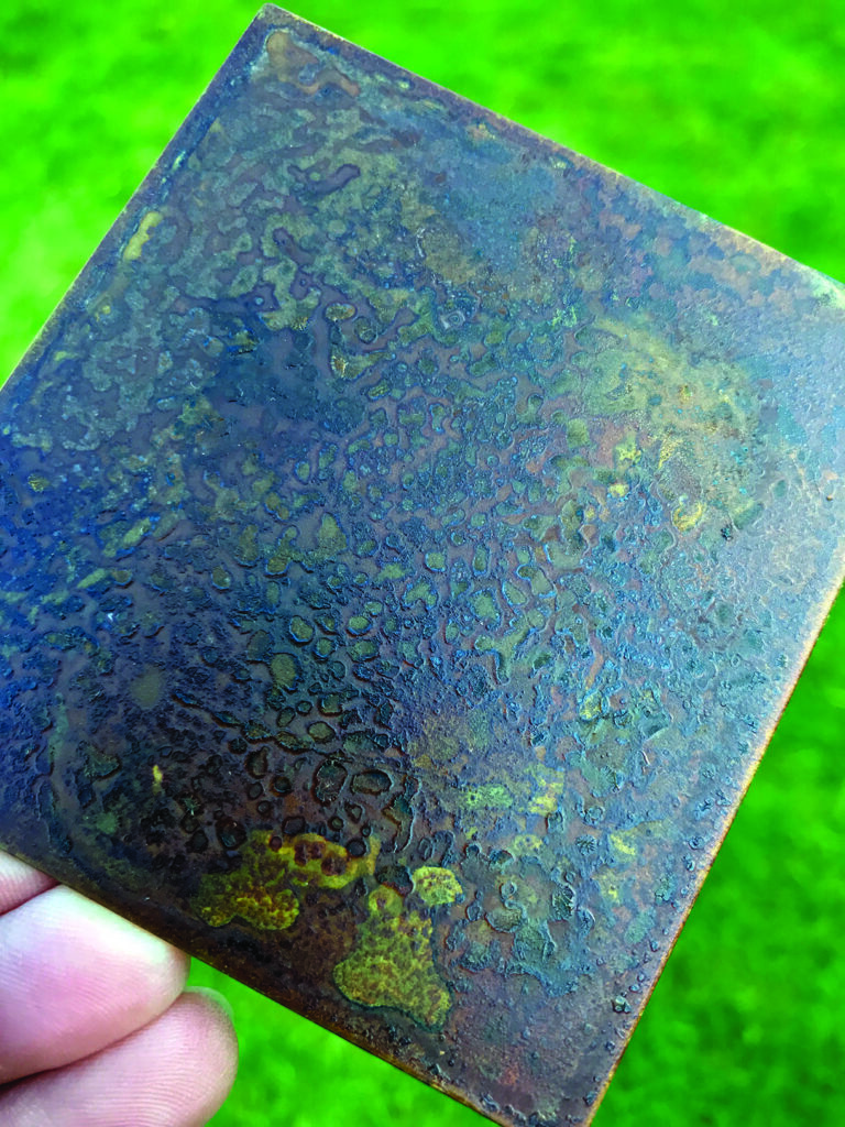 Oxidised metal surface with colourful patina pattern.