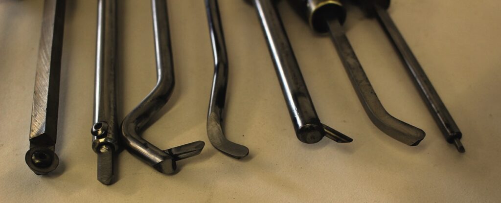 Various lathe cutting tools on a workshop table.