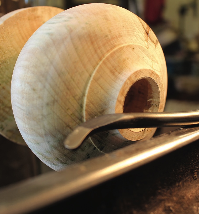 Woodturning with a lathe in workshop.