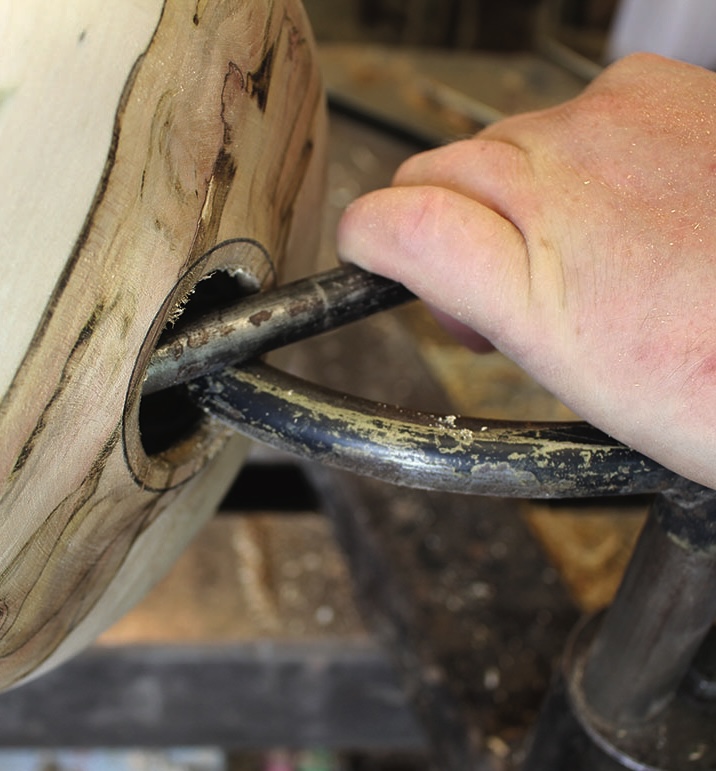 Hand using a lathe on wooden bowl