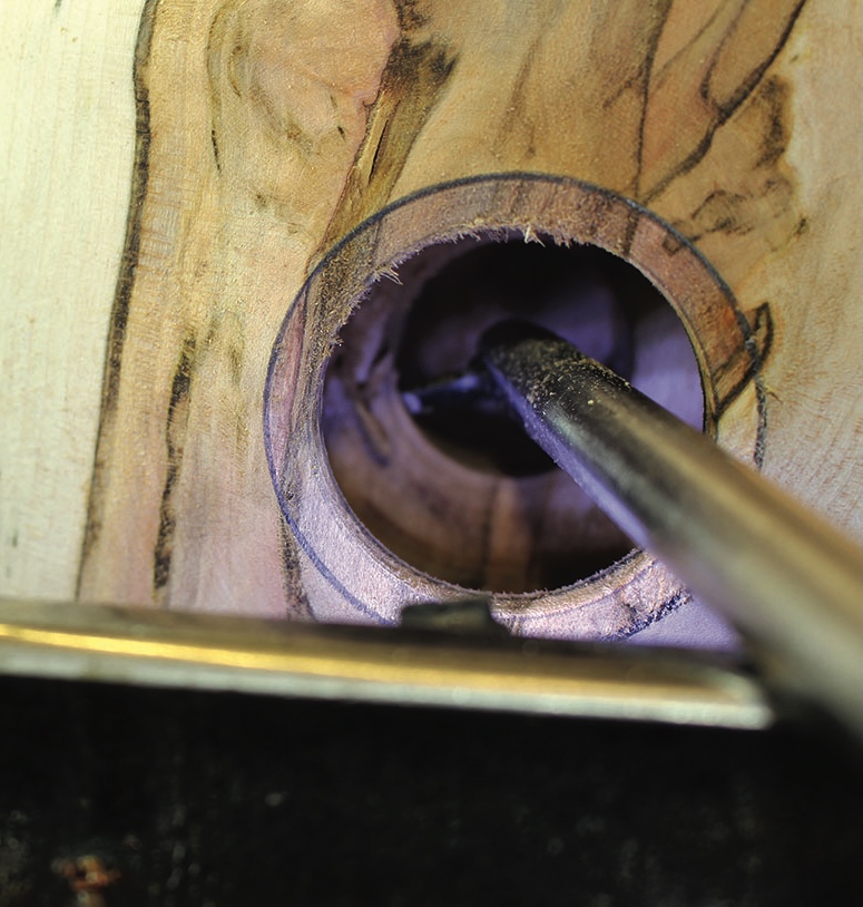 Close-up of wood drilling process in workshop.