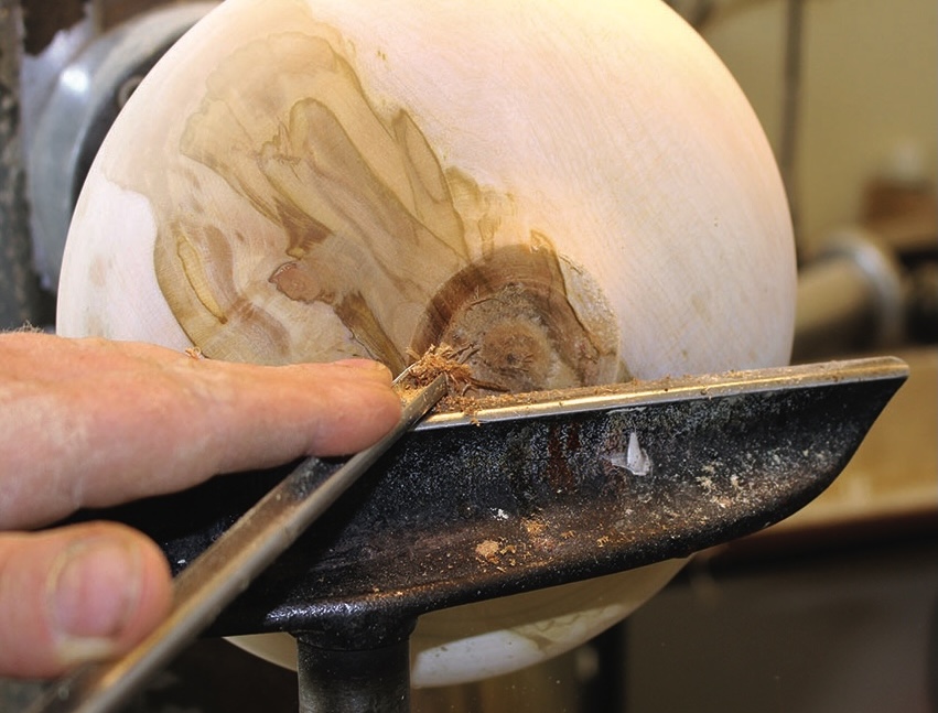 Hand carving wood on a lathe