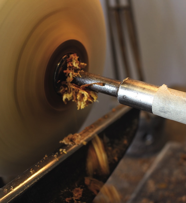 Lathe shaping wood into a spindle.