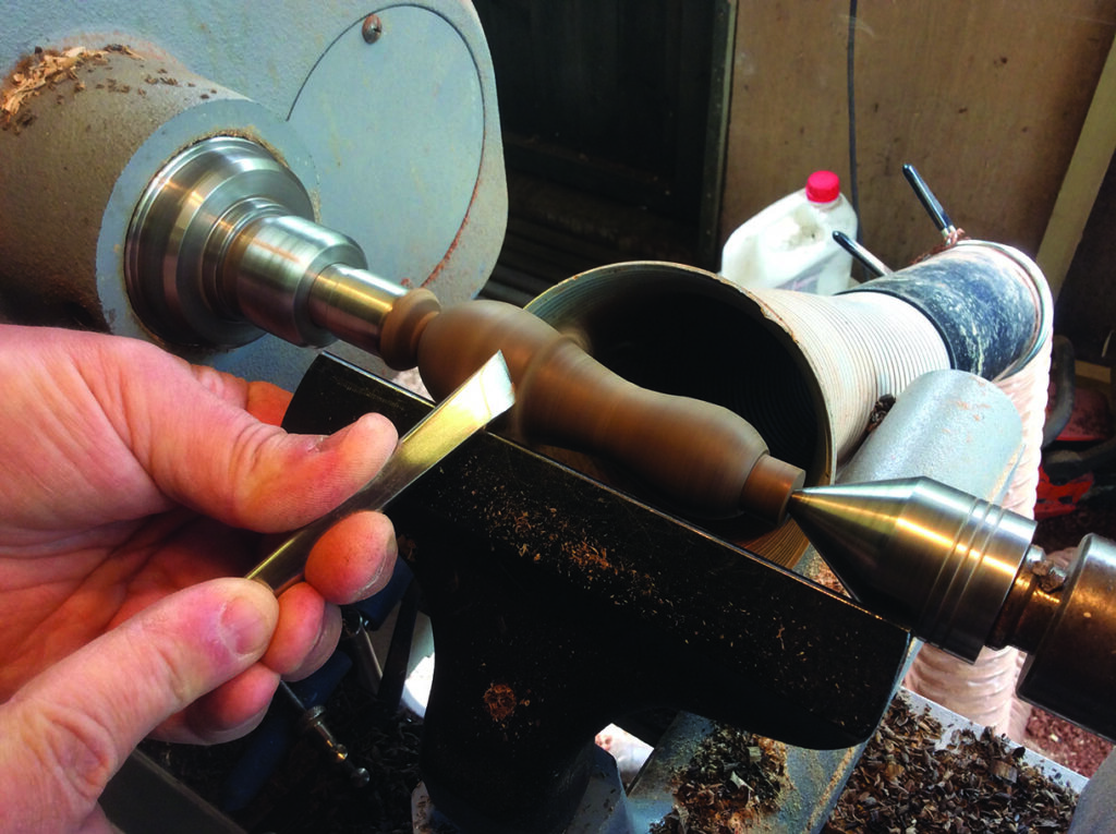 Woodturning with lathe and chisel in workshop.