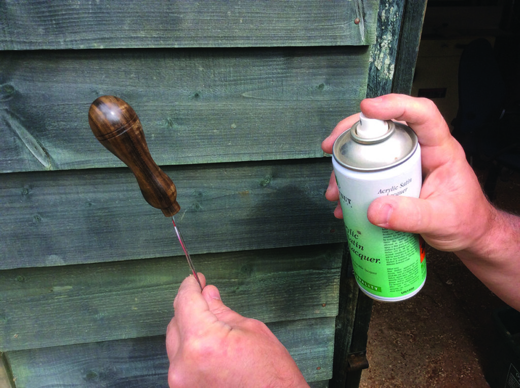 Varnishing wooden handle with spray lacquer.