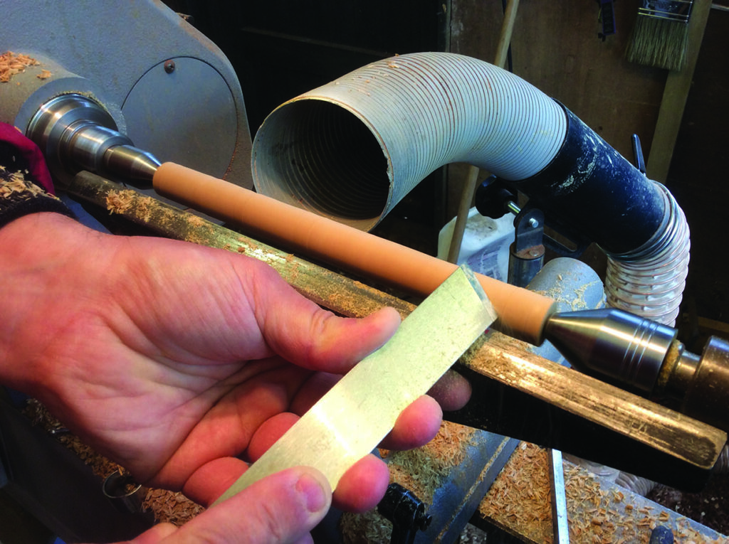 Woodturning process with lathe and tool.