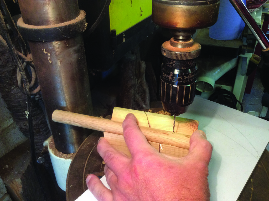 Drilling hole in wooden handle with drill press.