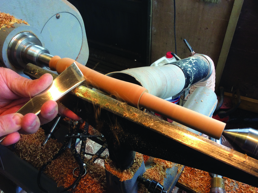 Woodturning on a lathe with chisel tool.