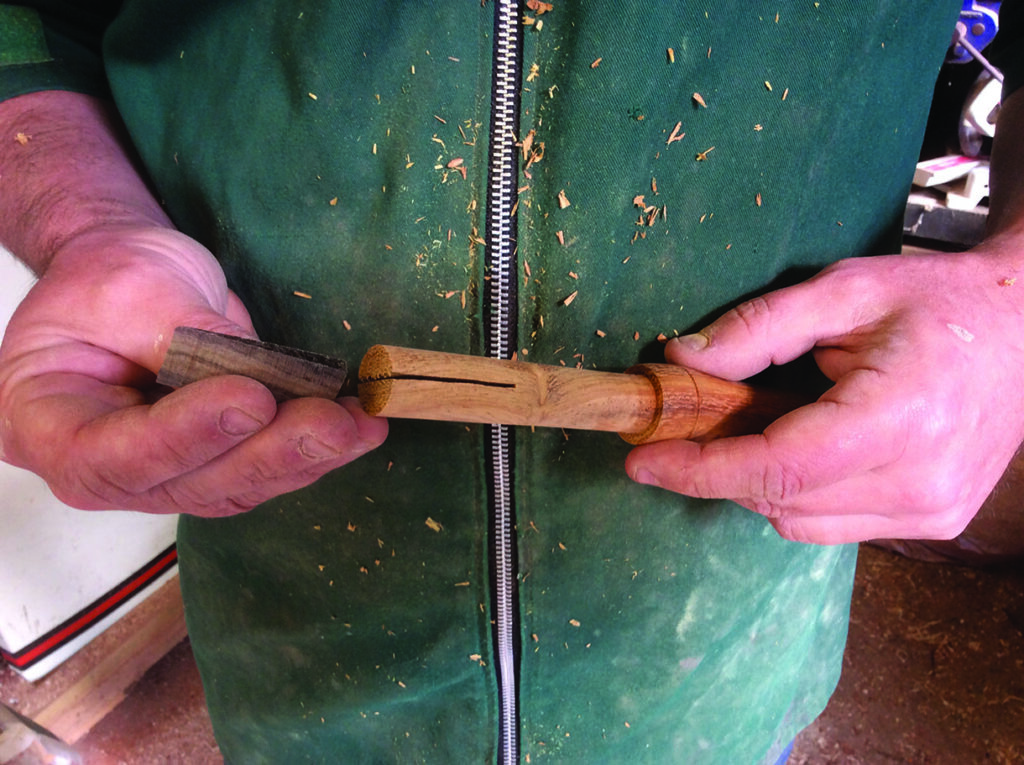 Woodworker holding carved wooden pieces