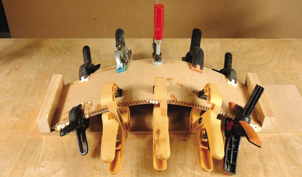 Wood bending with clamps on a workbench