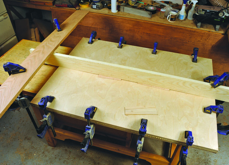 Woodworking project with clamps on a workbench.