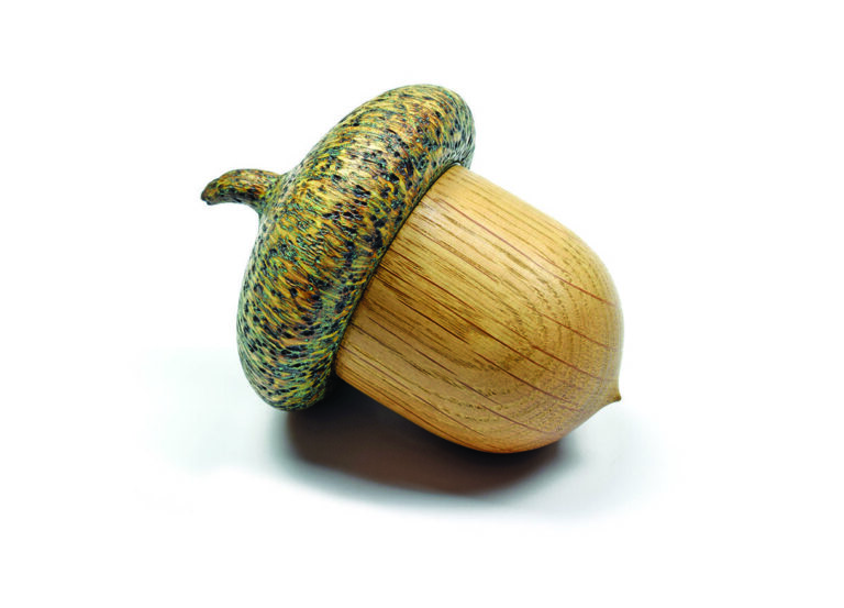 Wooden acorn sculpture with detailed texture.