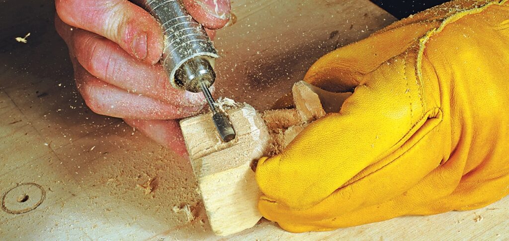 Person drilling into wood with rotary tool.