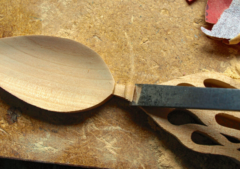 Wooden spoon being carved with a chisel