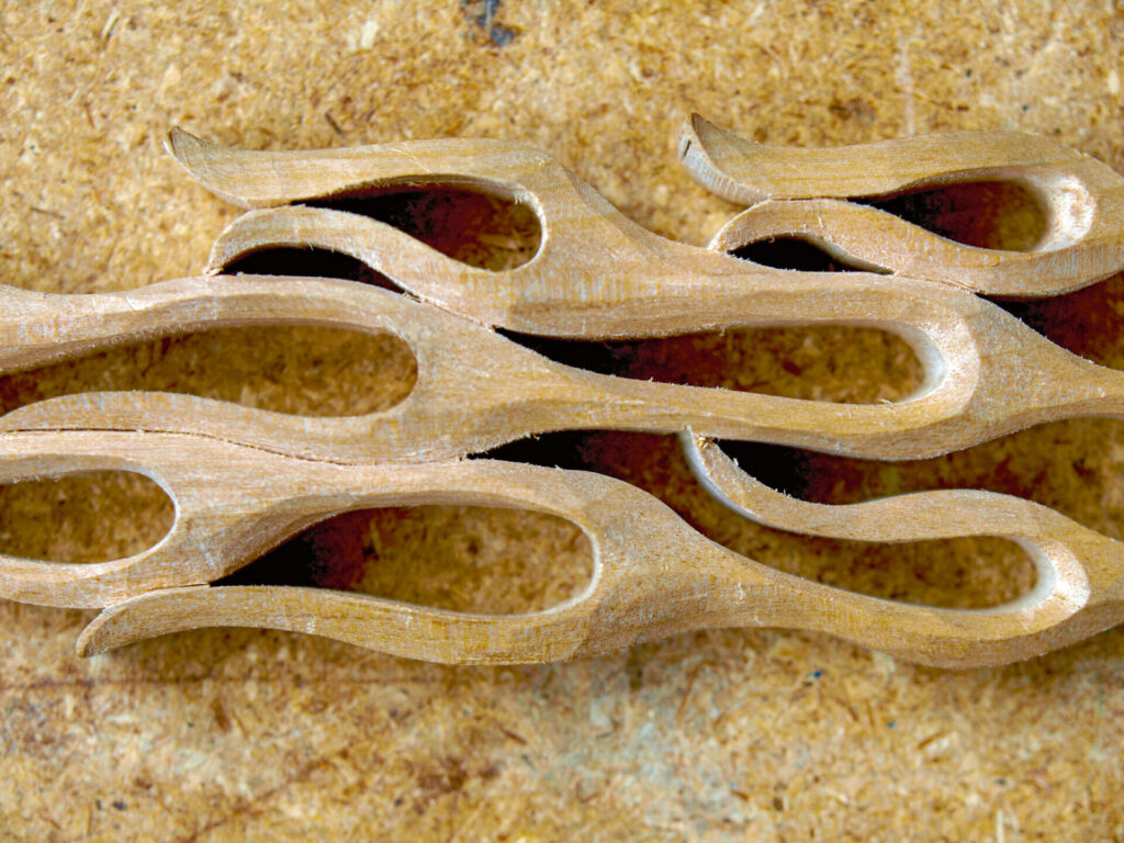 Intricate abstract wooden carving on textured surface.