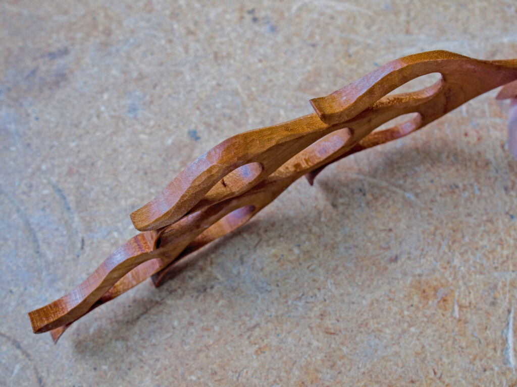 Intricate wooden sculpture on a textured surface.