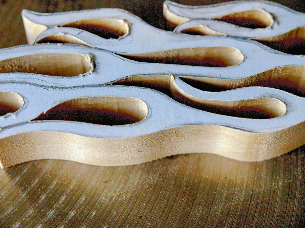 Close-up of abstract wooden wavy sculpture.