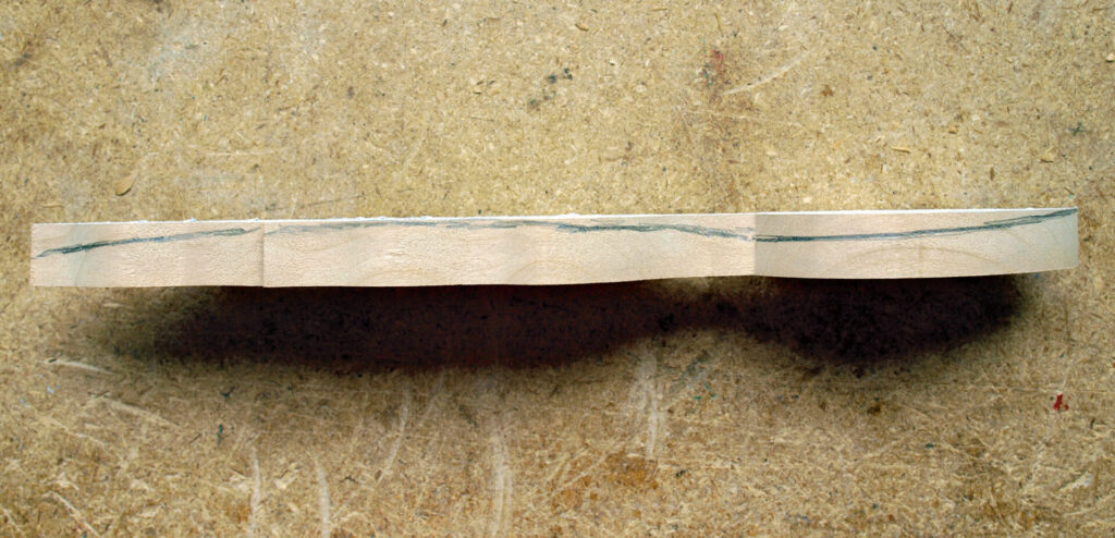 Curved laminated wood piece on textured surface
