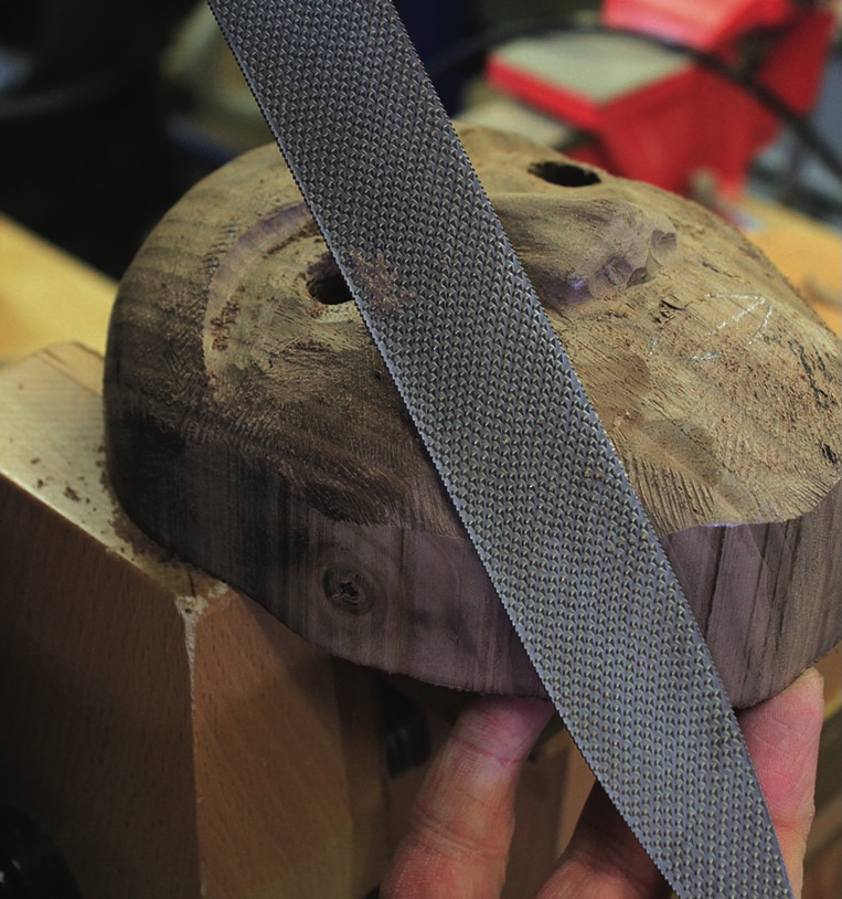 Wood carving process using a metal file tool.