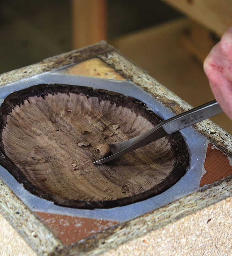 Chisel carving on wood block close-up.