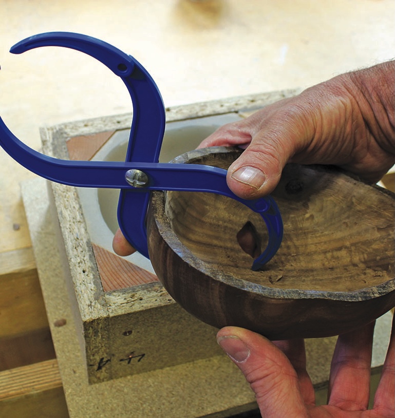 Using blue calliper on wooden bowl in workshop