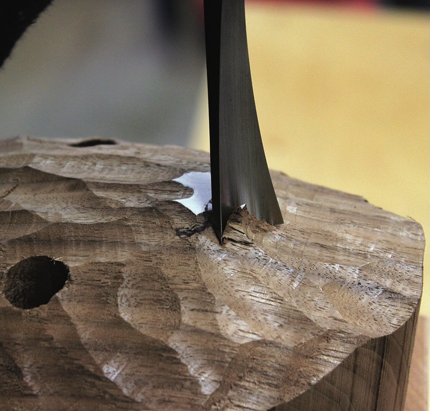 Chisel carving intricate wood texture with precision.