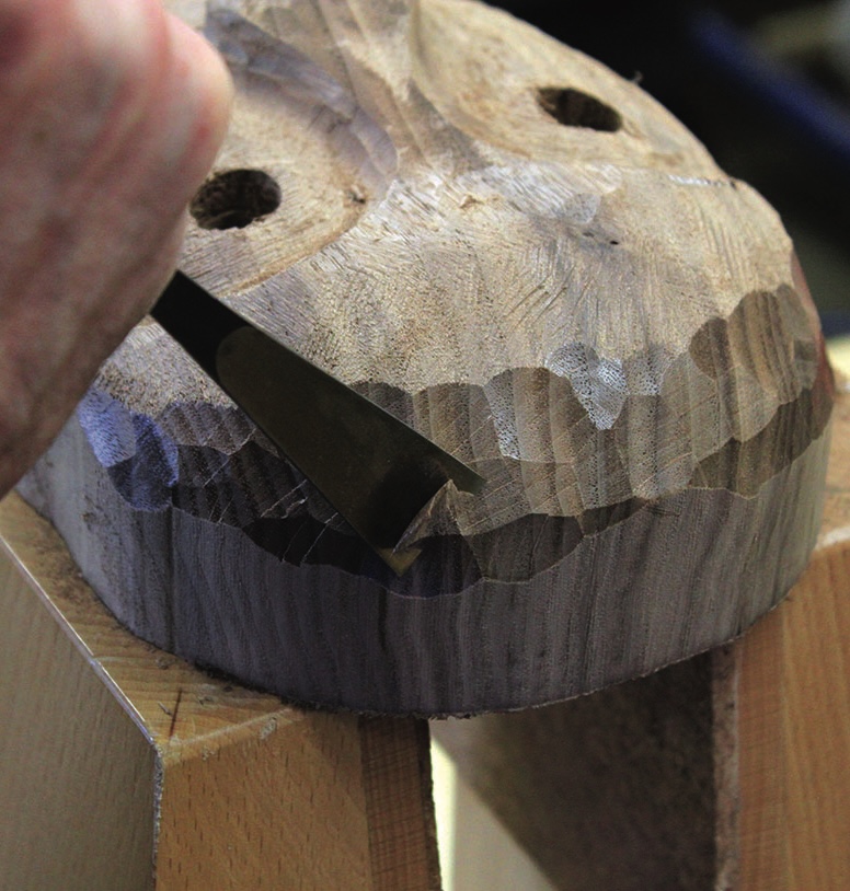 Close-up of wood carving with chisel.