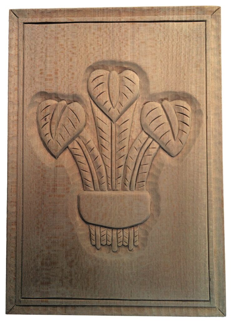 Wooden carving of leaves in vase design.