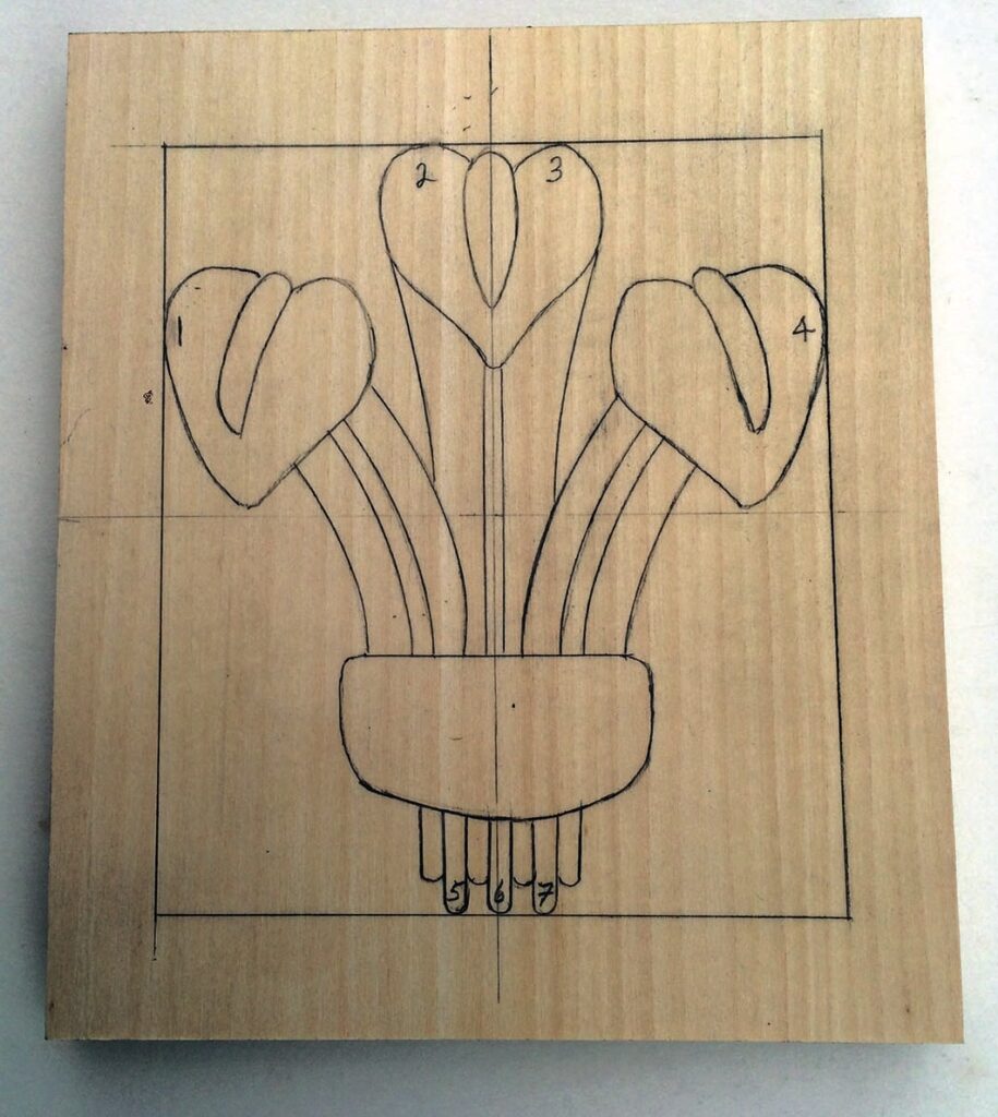 Simple carved flower design on wooden block.