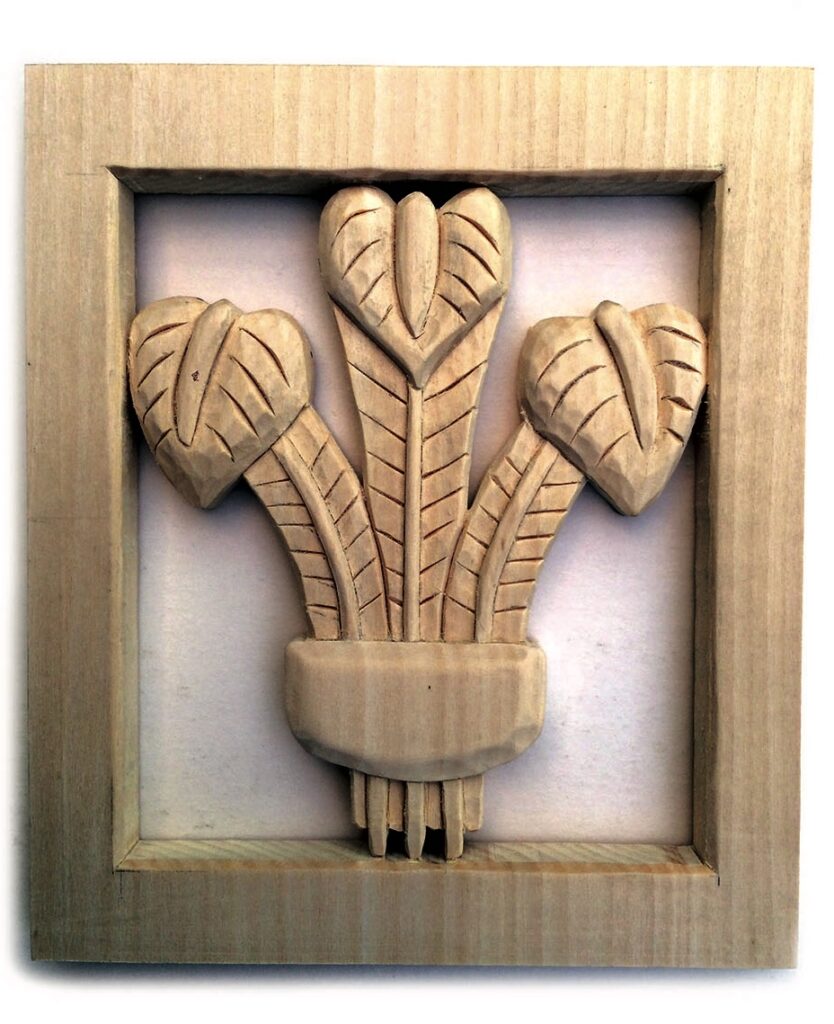 Wood carved fleur-de-lis in rectangular frame.