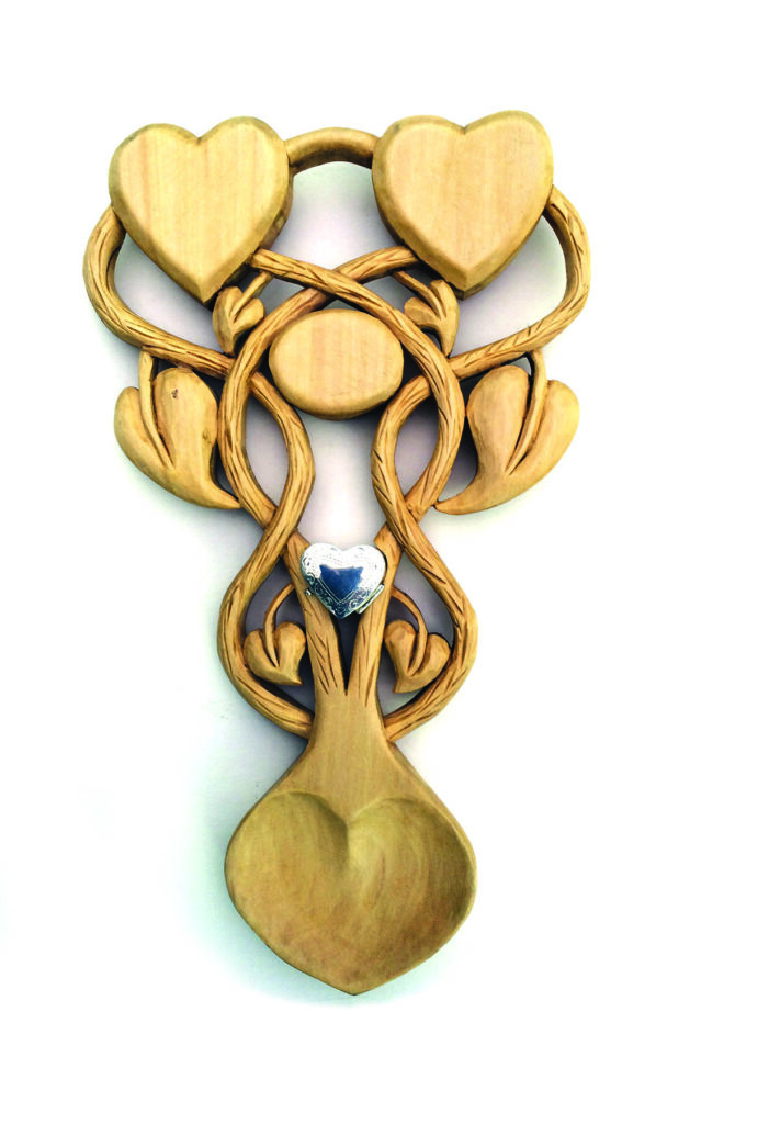 Intricate wooden spoon with heart shapes.