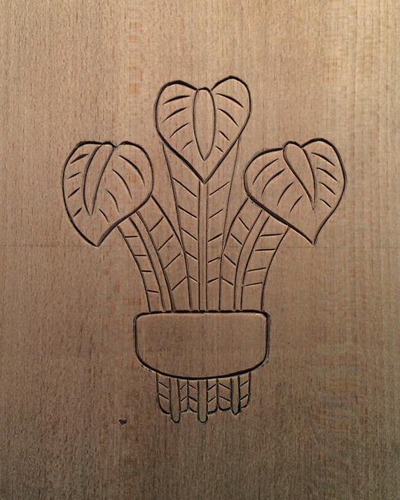 Wood engraving of potted plant with heart-shaped leaves.