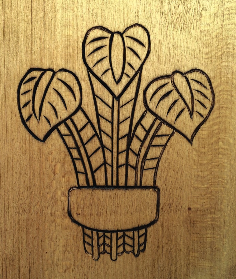 Engraved plant design on wooden surface
