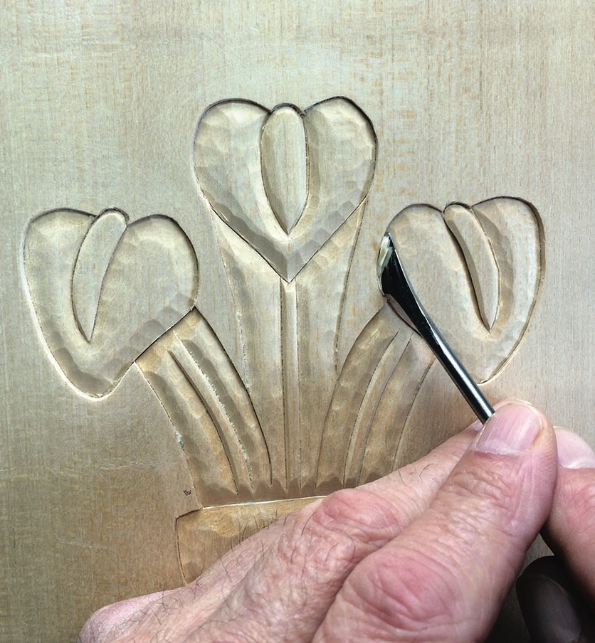 Hand carving flower pattern in wood.