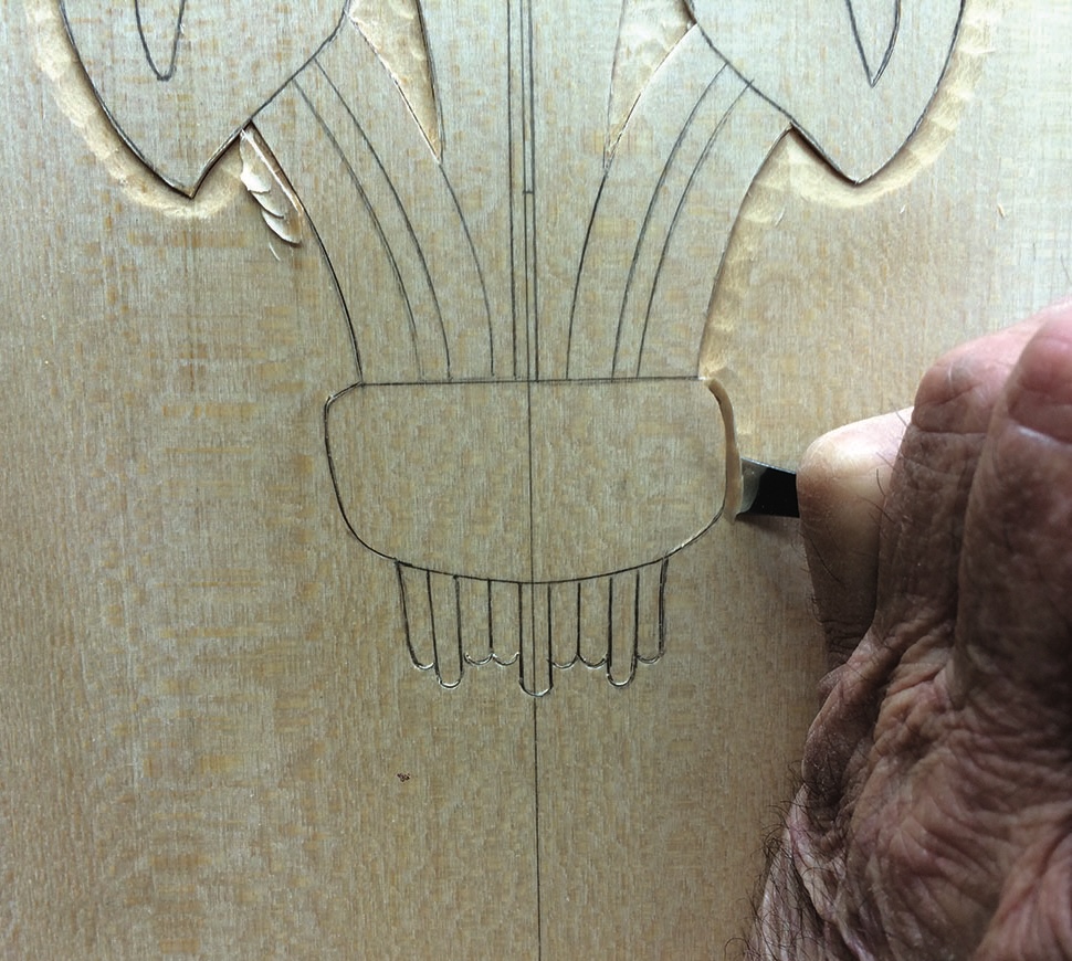 Hand carving wood with floral design outline.