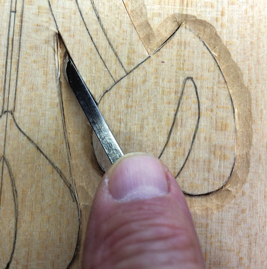 Wood carving detail with chisel and hand