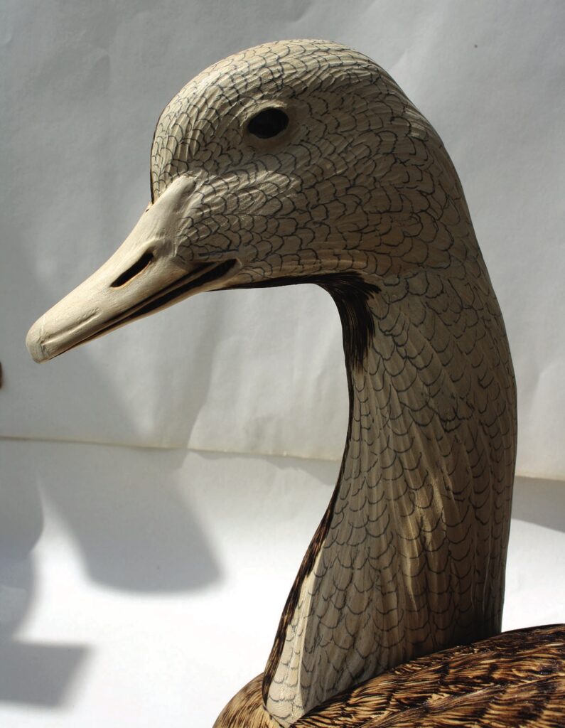 Hand-carved wooden duck figurine with detailed features.