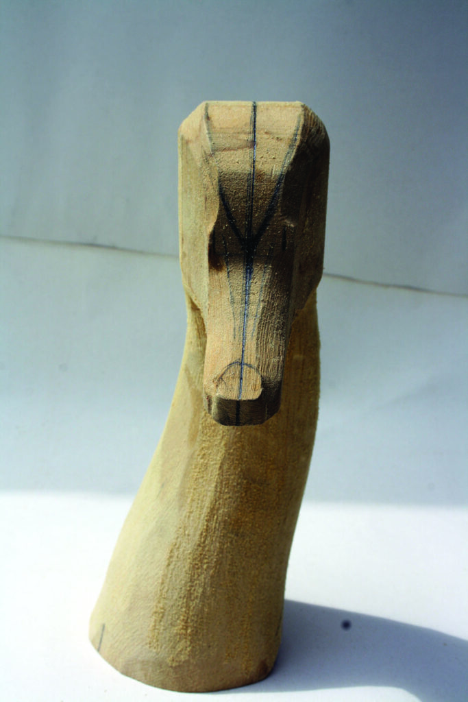 Wooden duck head carving with pencil markings.