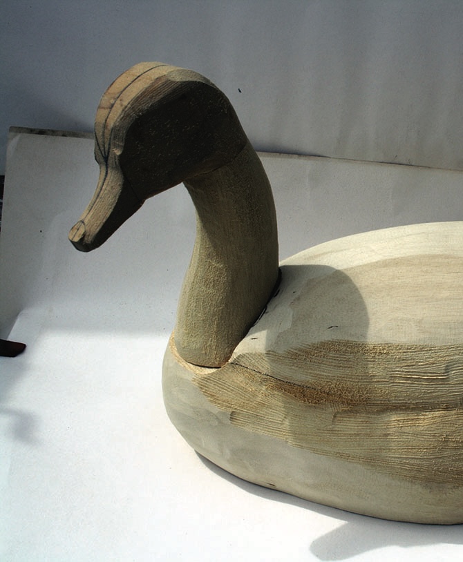 Carved wooden duck on white background.