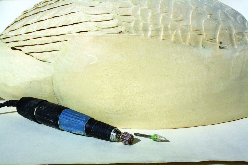 Wood carving tools on carved wooden surface.