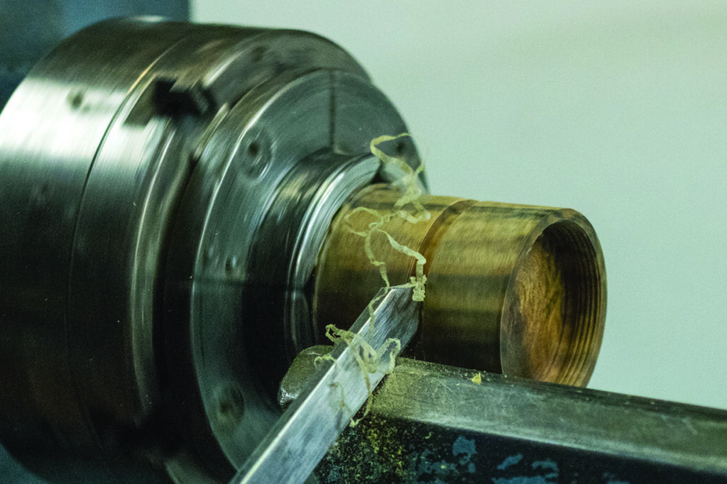 Metal lathe shaping a cylindrical object.