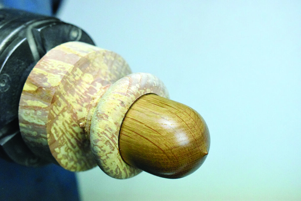 Wooden sculpture on a lathe machine close-up.